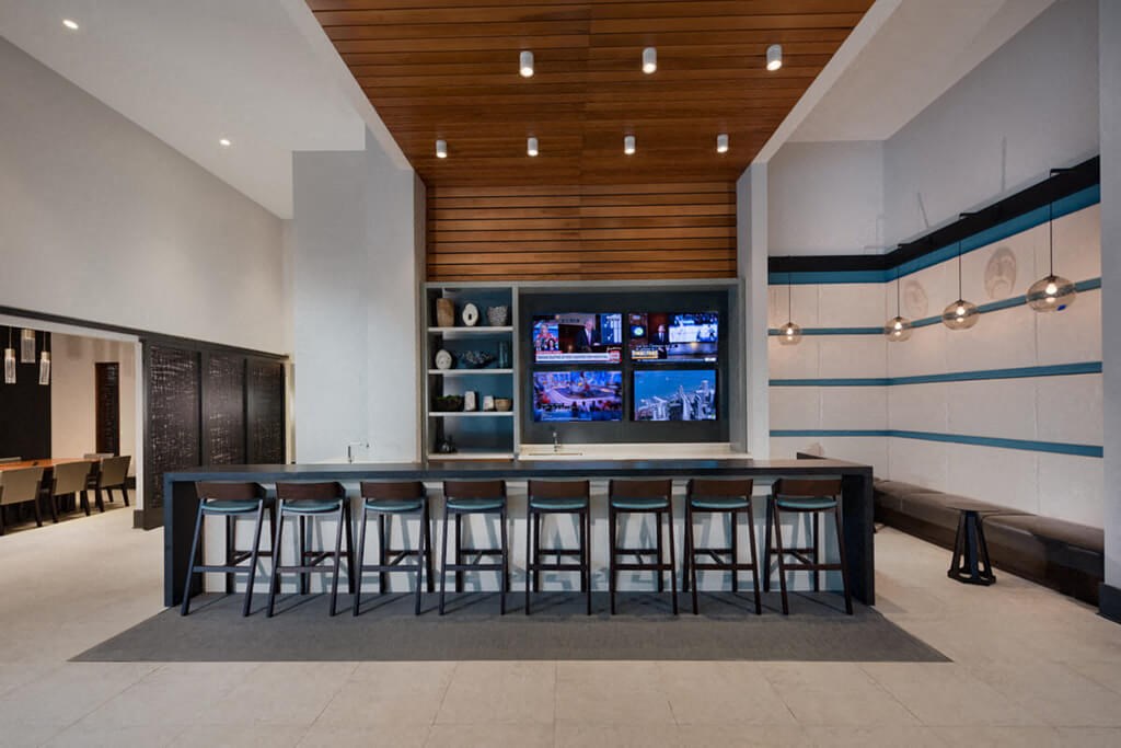 a bar with stools in a room with a television