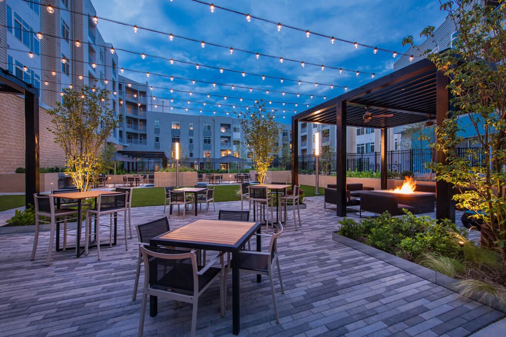 a patio with tables and chairs and a fire pit