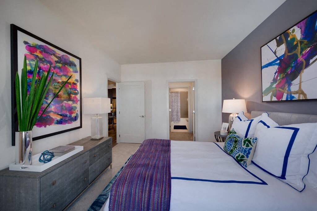 a bedroom with a bed and a painting on the wall