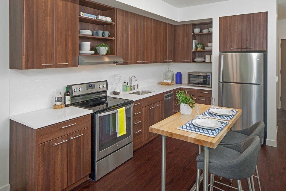 South Portland OR Apartments - Oxbow49 - Large Kitchen with Wood-Style Flooring, Wood-Style Cabinetry, Stainless Steel Appliances, and a Kitchen Island