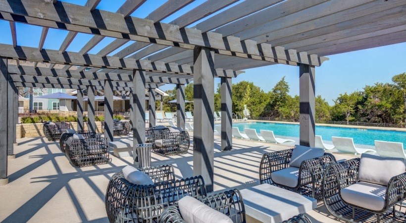 Georgetown, Texas Apartments - Williamson at The Overlook - Poolside Lounge Area with Multiple Chair Seating Areas Under Pergola