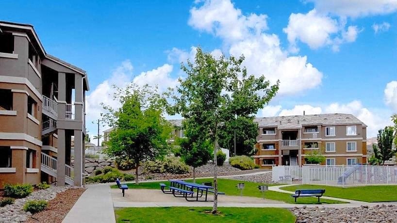 a park with benches in front of some buildings