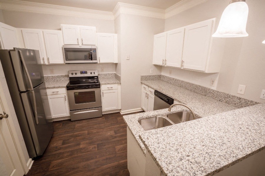 Stainless steel appliances in modern designer kitchens at The Asher at Sugarloaf, a pet-friendly community in Lawrenceville, GA, near Duluth.