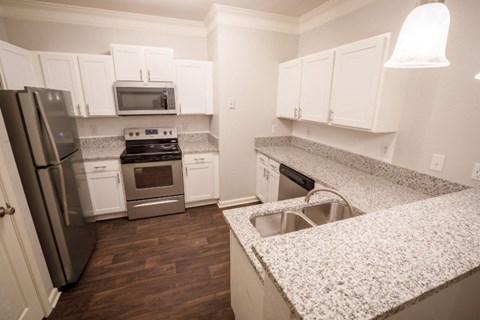 a kitchen with granite counter tops and stainless steel appliances