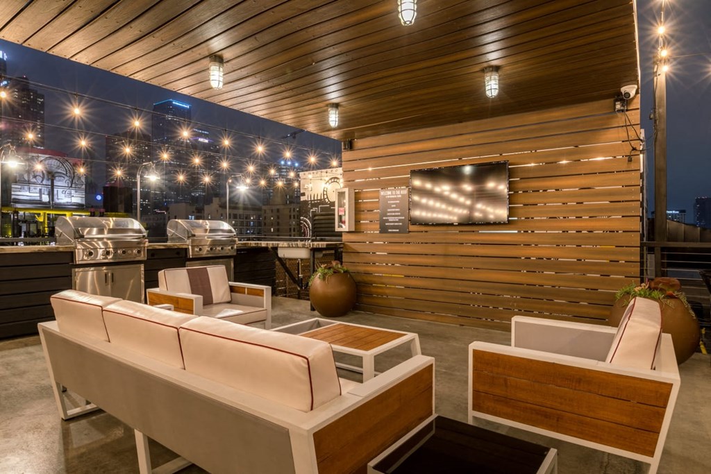 a lounge area with couches and chairs and a bar with a grill