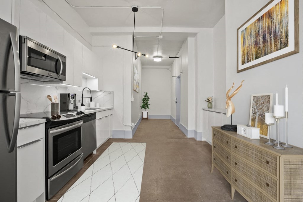 a kitchen with white cabinets and stainless steel appliances