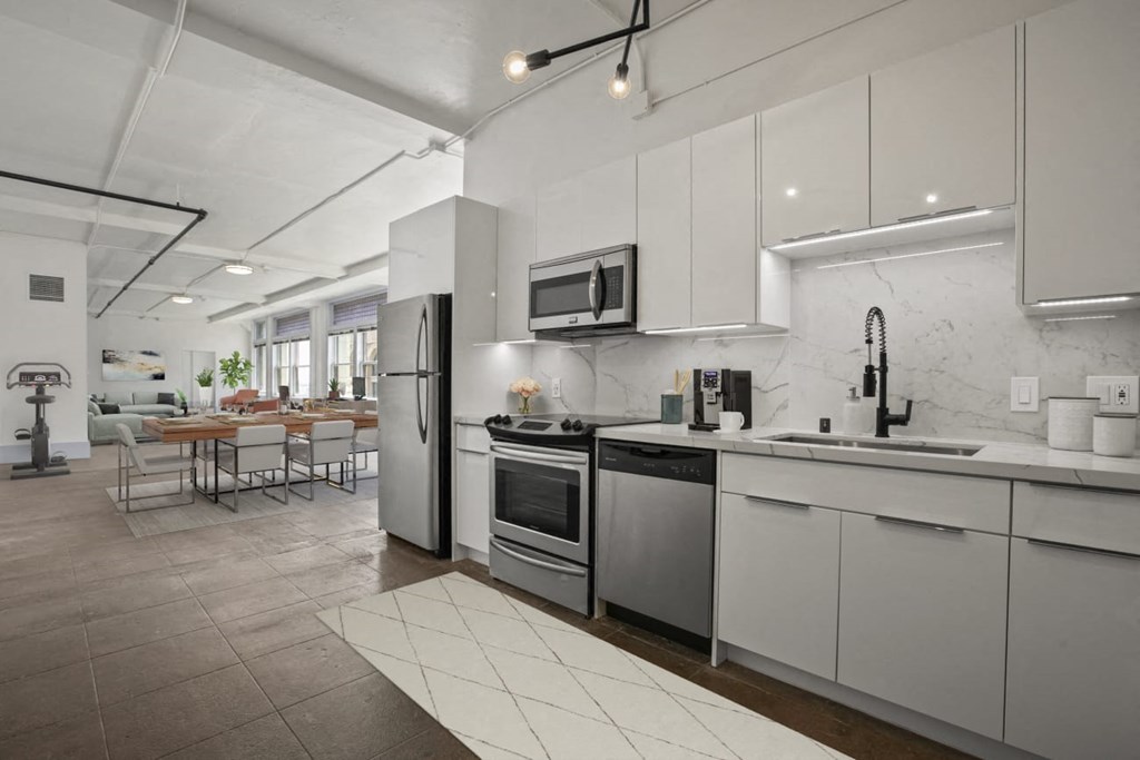 a kitchen with white cabinets and stainless steel appliances