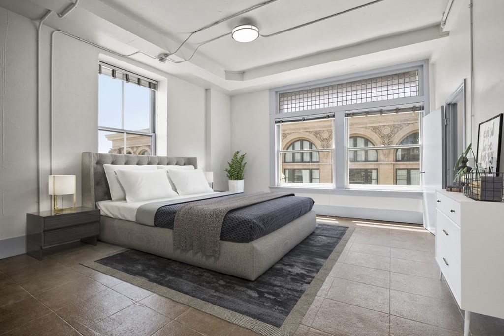 Downtown Los Angeles, CA Apartments for Rent - Santa Fe Lofts - Bedroom with Original Concrete Flooring and Hexagonal Plaster Detail, High Ceilings, Skylight, Oversized Windows, and Gorgeous Views of the City