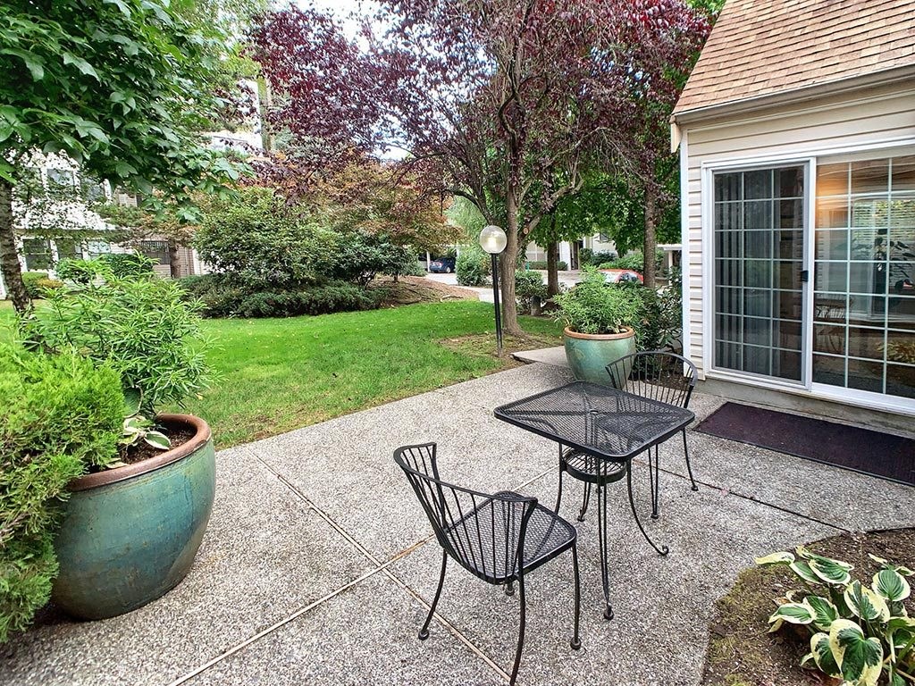 a patio with a table and chairs and a house