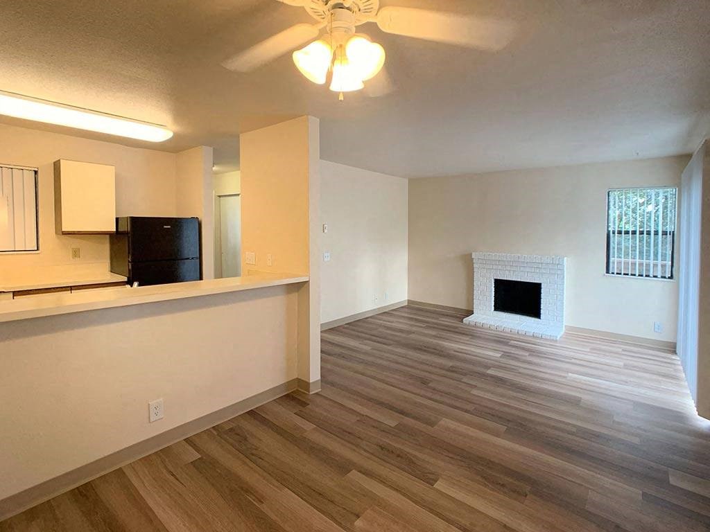 a living room with a fireplace and a kitchen