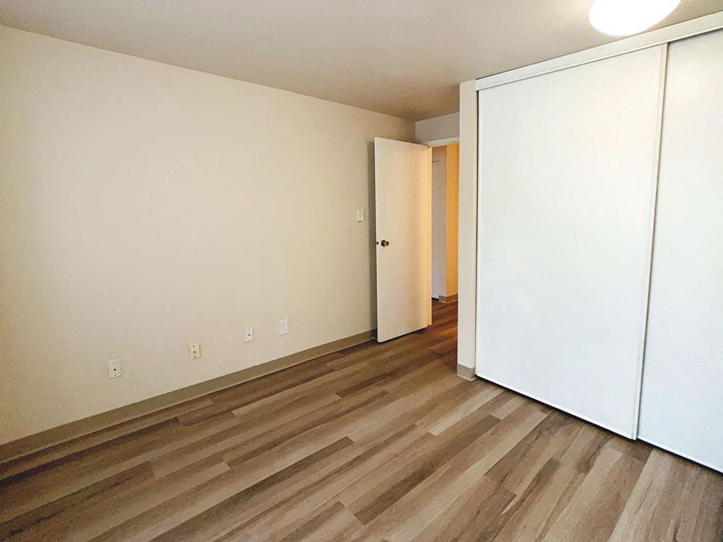 an empty room with white walls and wood floors
