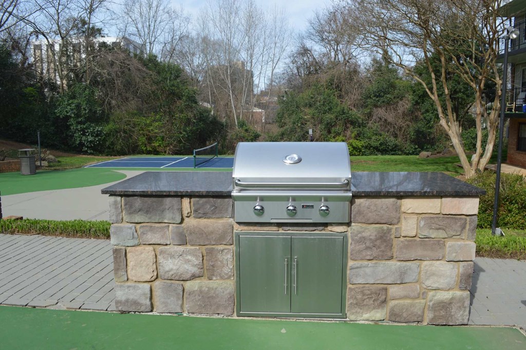 the outdoor grill is set into a stone wall with a green door