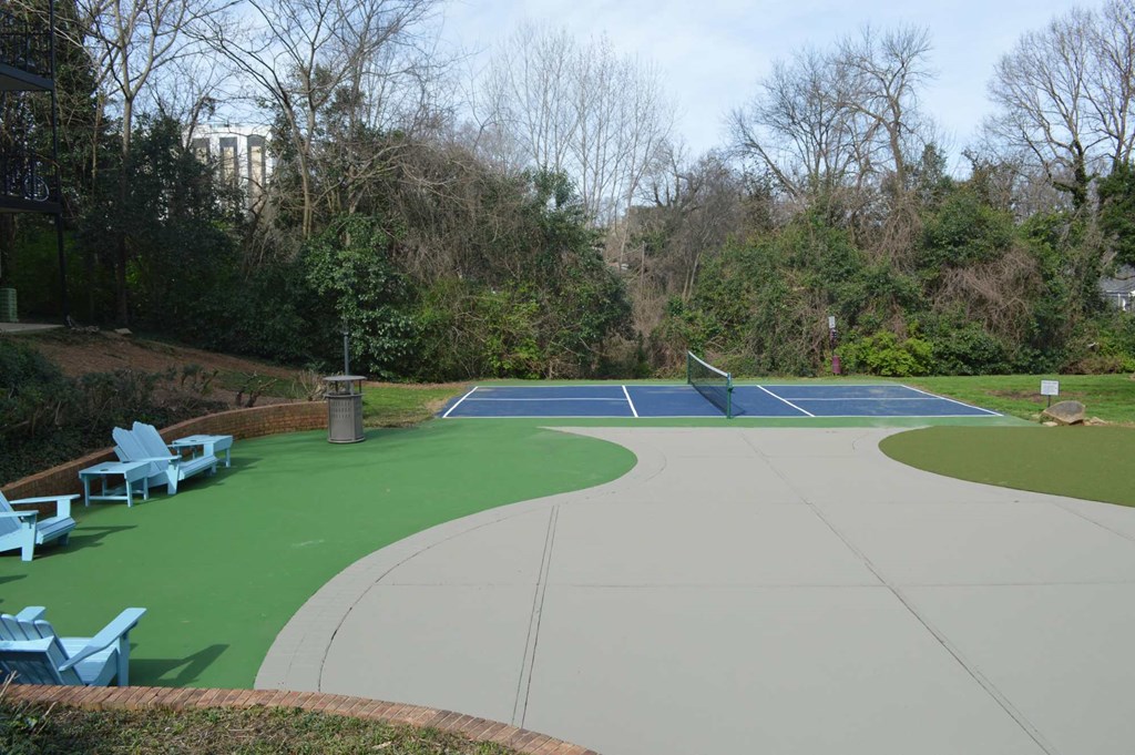 a tennis court with blue chairs around it
