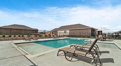 Homes in Lewisville, TX for Rent - The Villas at Rockbrook - Swimming Pool with Spacious Sundeck, Lounge Seats, Umbrella Tables, and Chairs.