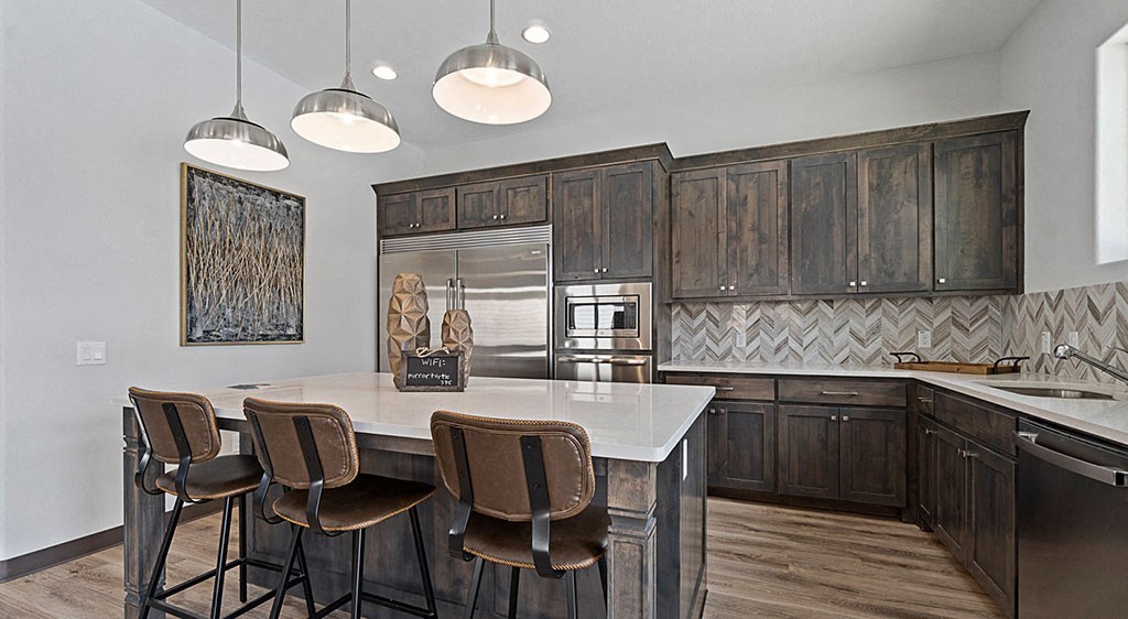 a kitchen with a large island with four chairs