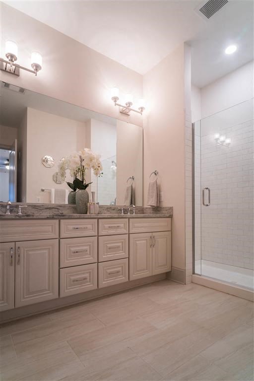 a bathroom with a sink and a shower and a mirror