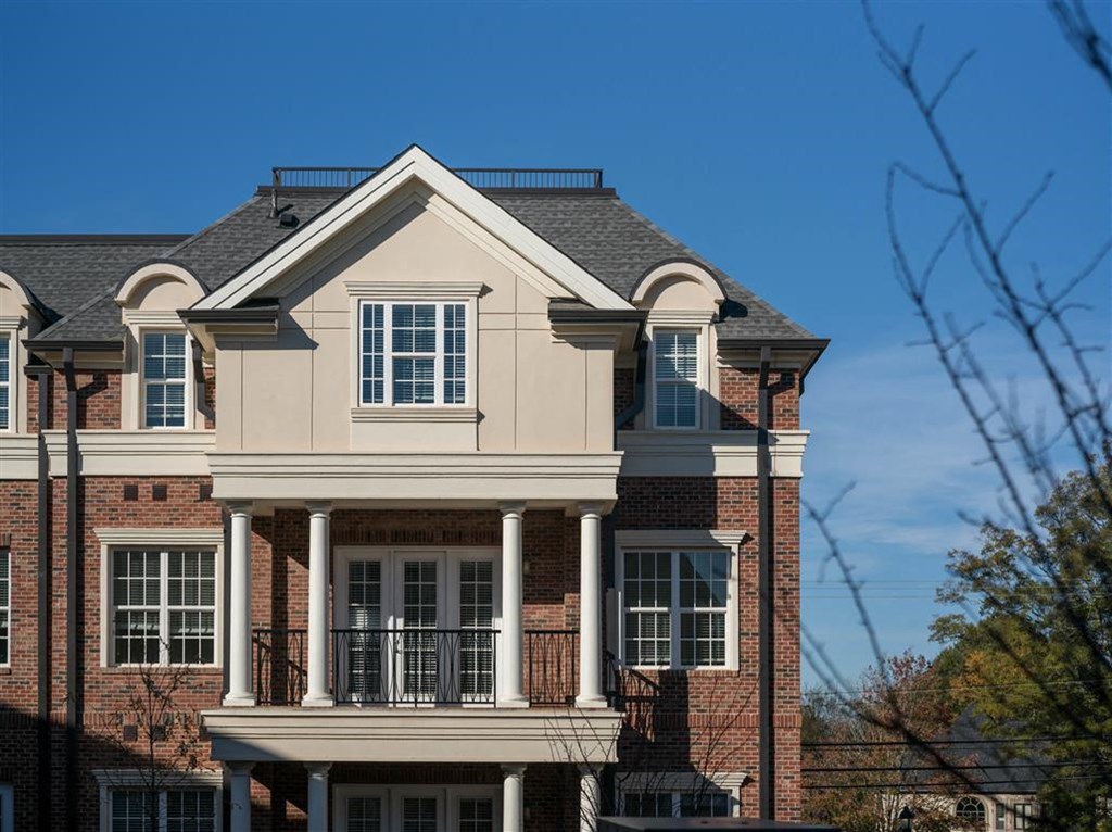 a large brick house with a balcony and a blue sky