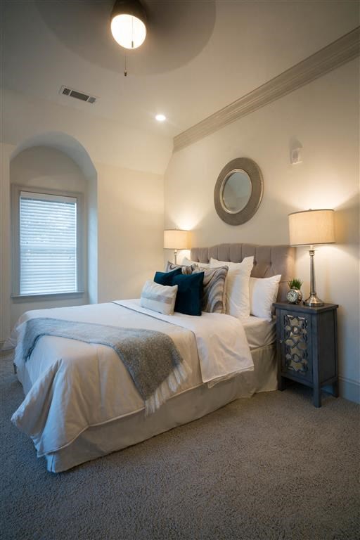 a bedroom with a bed and a mirror on the wall