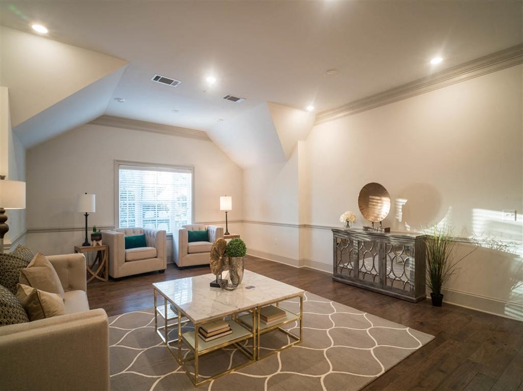 A bright sitting room with modern decor, armchairs, and a coffee table.