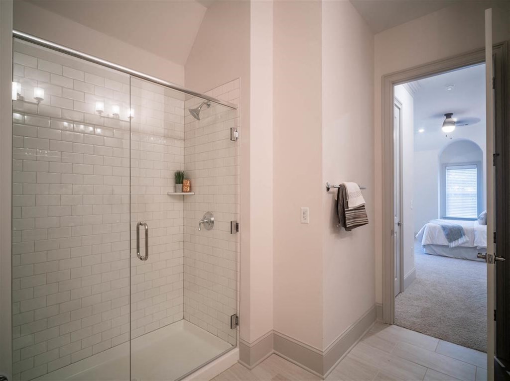 a white bathroom with a shower and a bed
