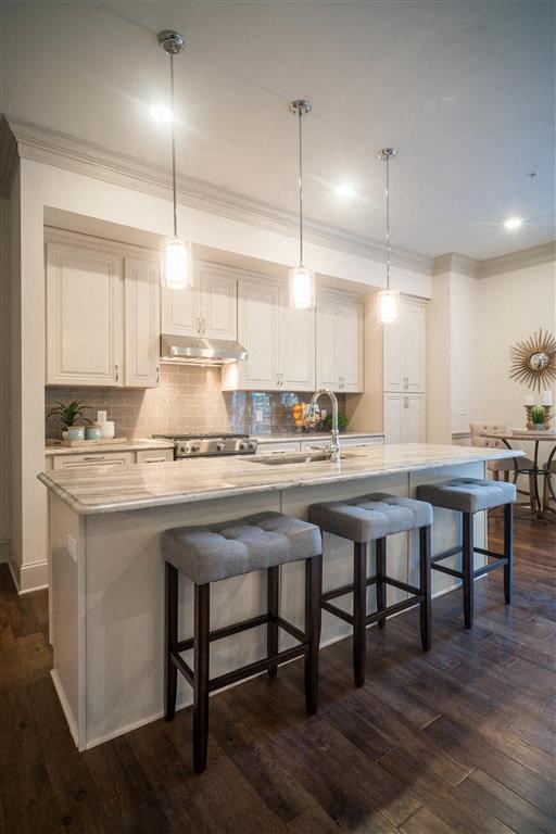 a kitchen with a large island with four stools