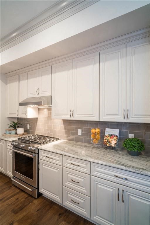 a kitchen with white cabinets and a stove