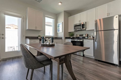a kitchen with stainless steel appliances and a wooden table