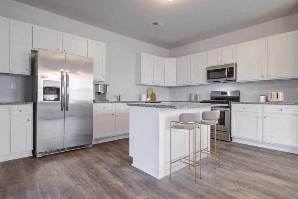 a large kitchen with white cabinets and stainless steel appliances