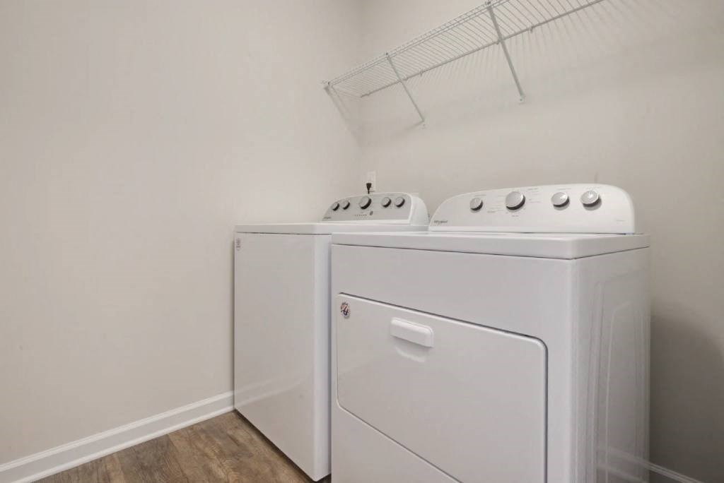 a washer and dryer in a white room with a rack on the wall