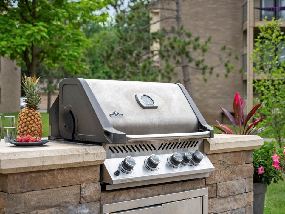 a grill and a pineapple on a stone counter in a backyard