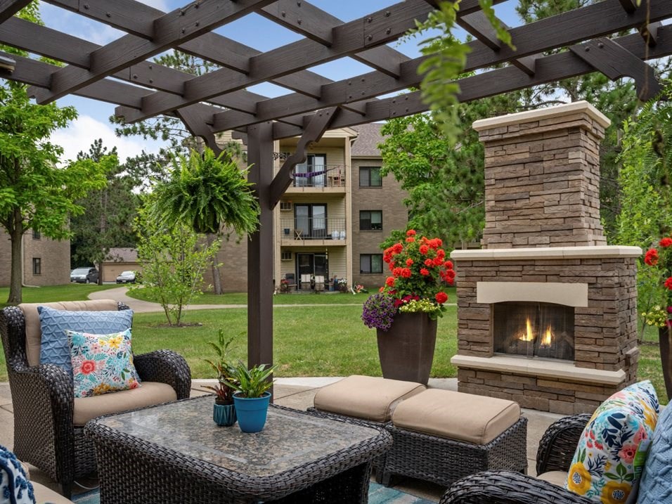 a patio with furniture and a fireplace  and a pergola