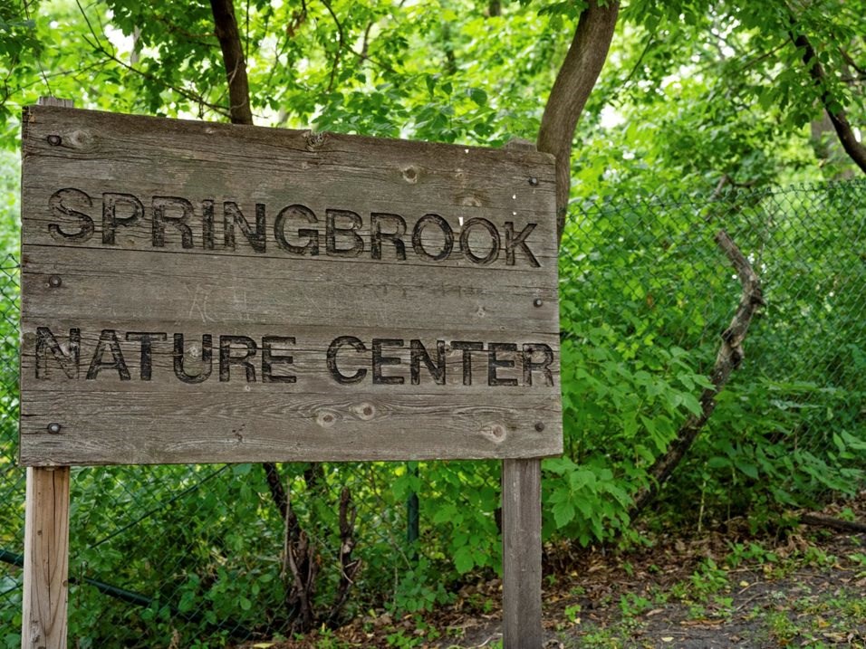 a sign for the springbrook nature center in the woods