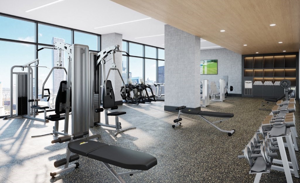 a gym with cardio equipment and a view of the city