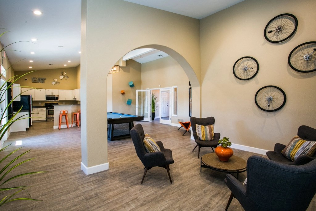 a living room with couches and chairs and a pool table