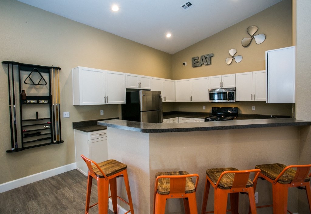 a kitchen with a bar and stools in front of a counter top and a