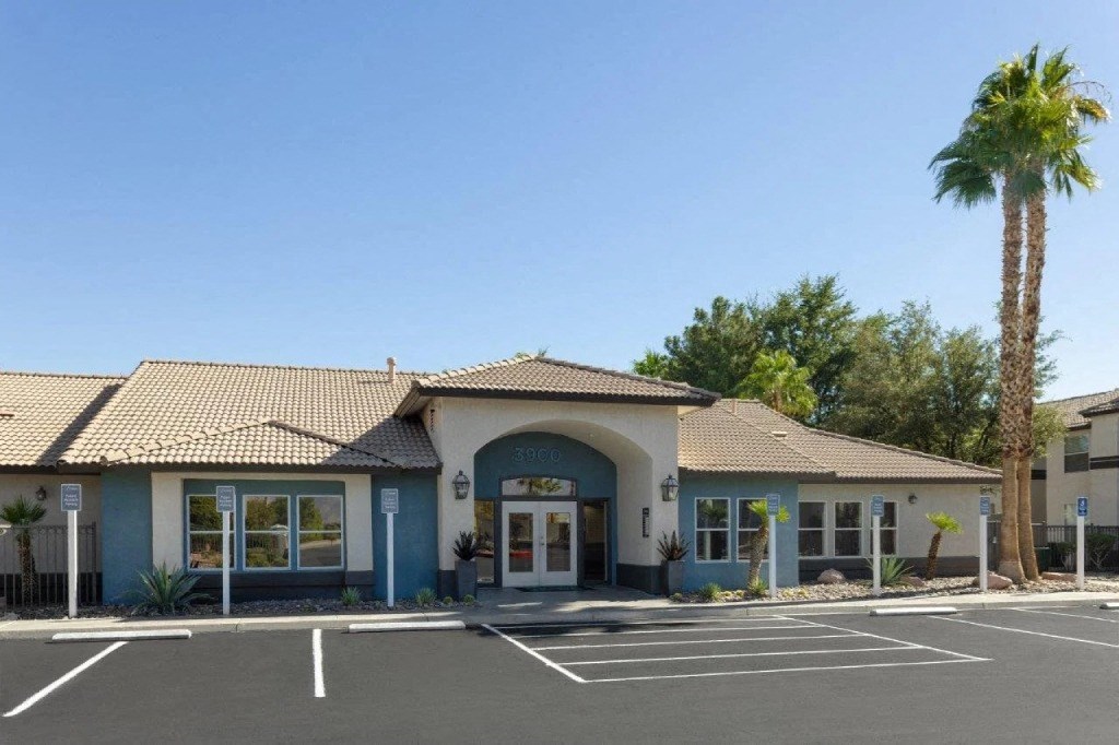 the front entrance of a building with a palm tree