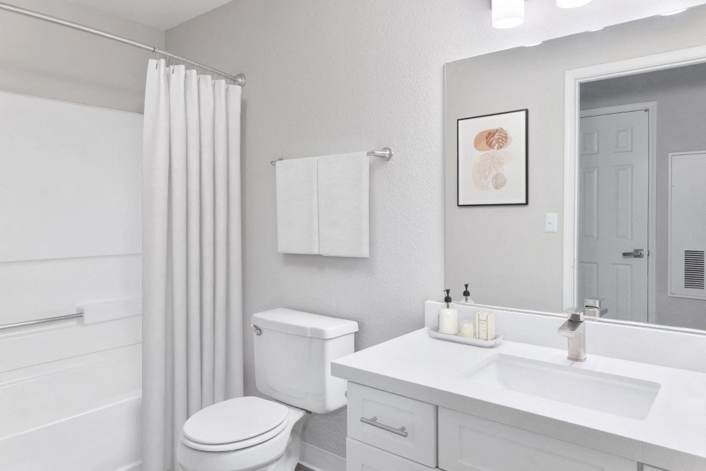 a white bathroom with a shower toilet and sink