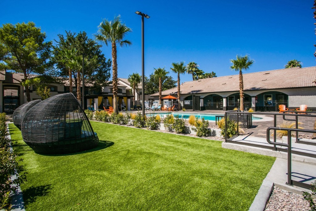 a backyard with a pool and a chair in the grass