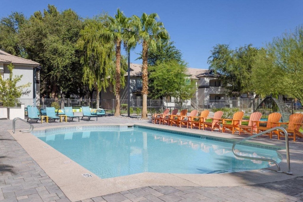 a swimming pool with orange and blue chairs around it