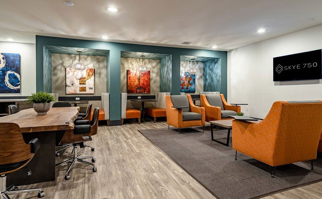 a conference room with blue walls and orange chairs and tables