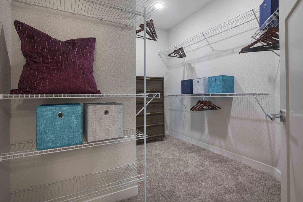 a walk in closet with a pillow and shelves in it