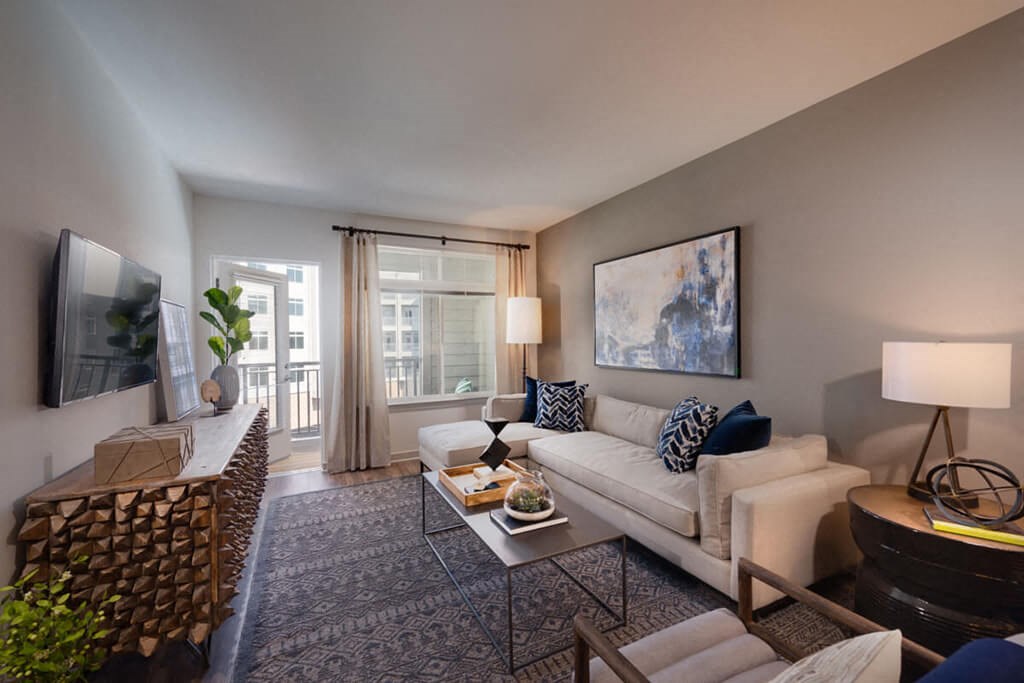 a living room with a white couch and a television