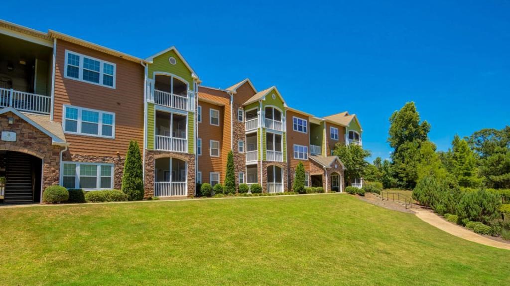 Pet-Friendly Apartments in Opelika, AL – The Crossings of Opelika - community building and grass area