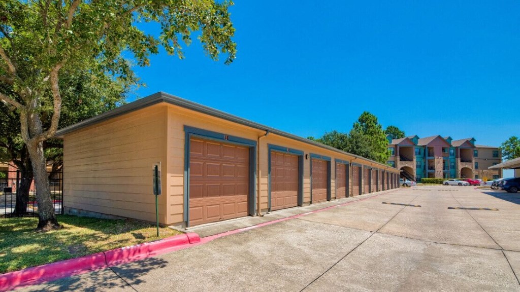 a long row of garages with cars parked next to them