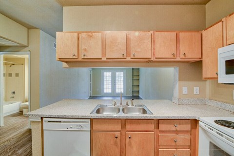 an empty kitchen with wooden cabinets and a sink
