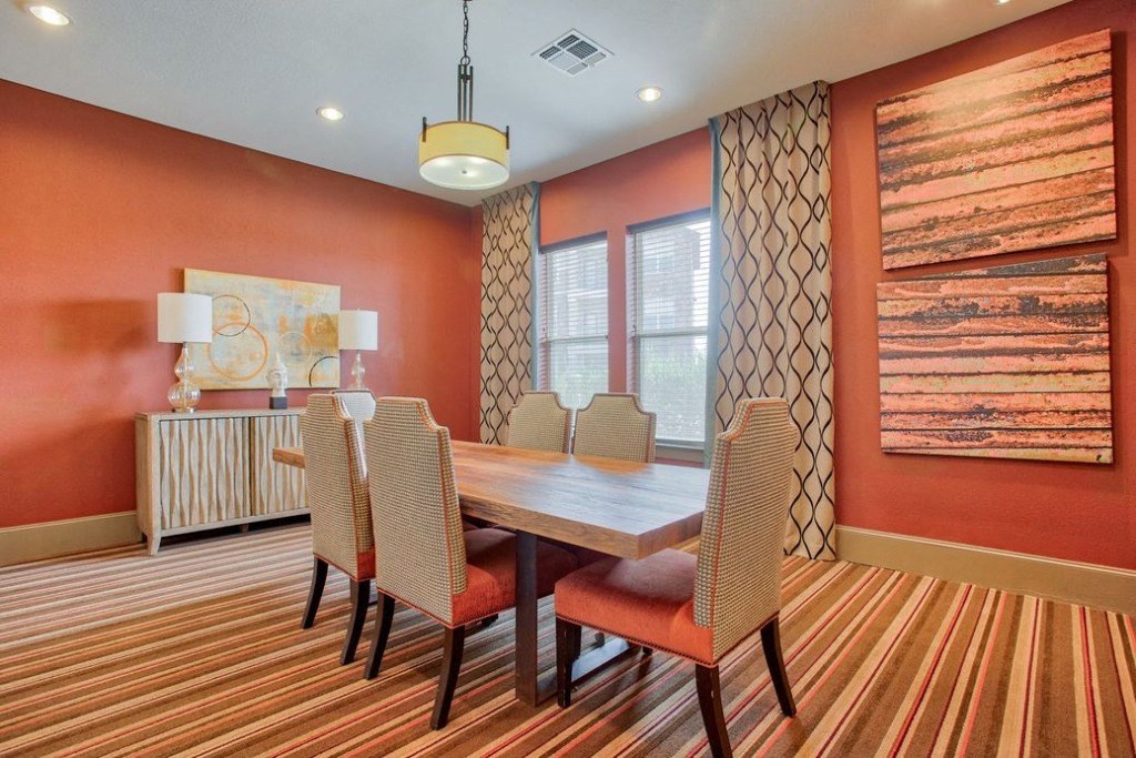 Private room with table in middle surrounded by chairs and windows
