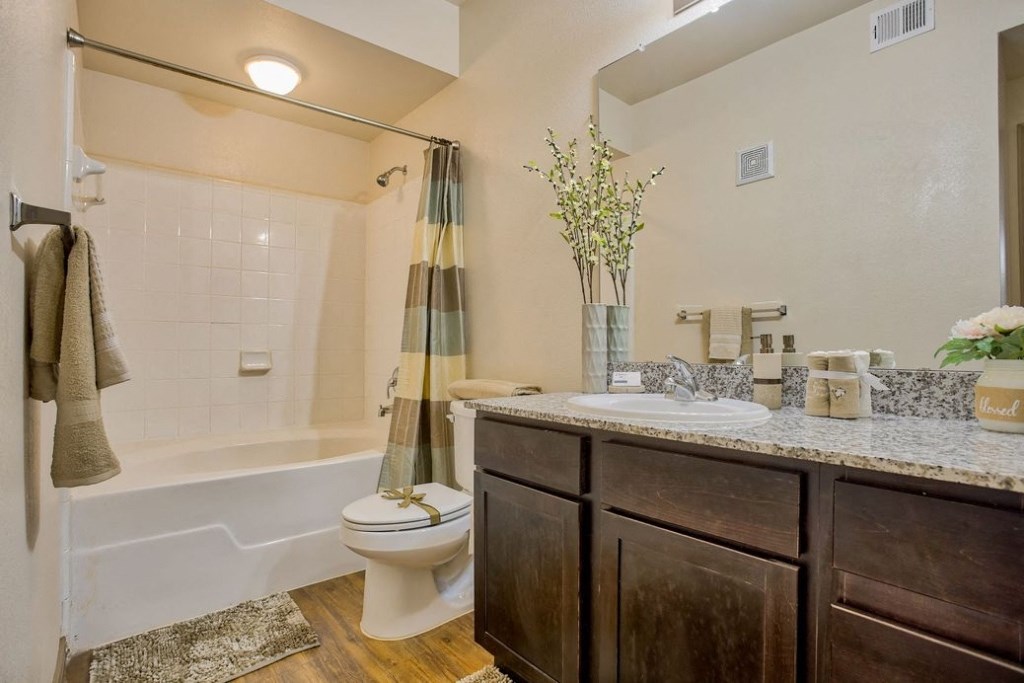 bathroom with a toilet and bathtub and sink and cabinets