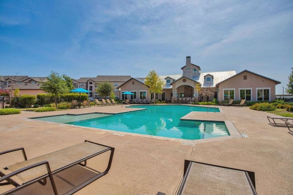 Giant Swimming pool beach chairs and building in background