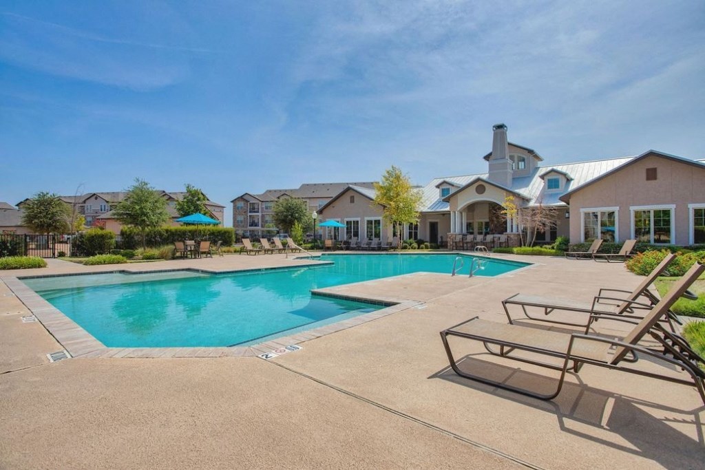 Giant Swimming pool beach chairs and building in background