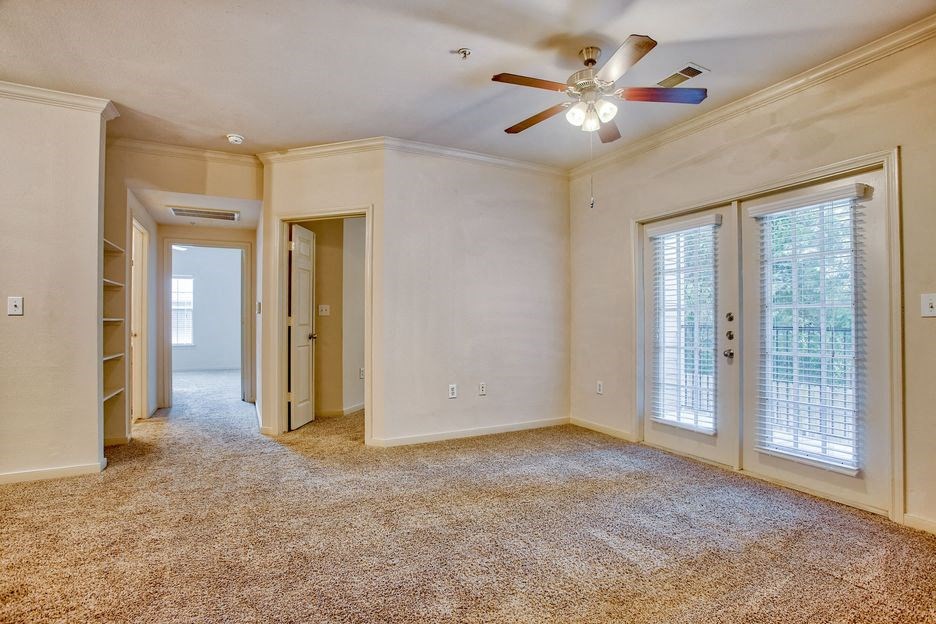 Living room with carpet, ceiling fan, glass doors and walkway